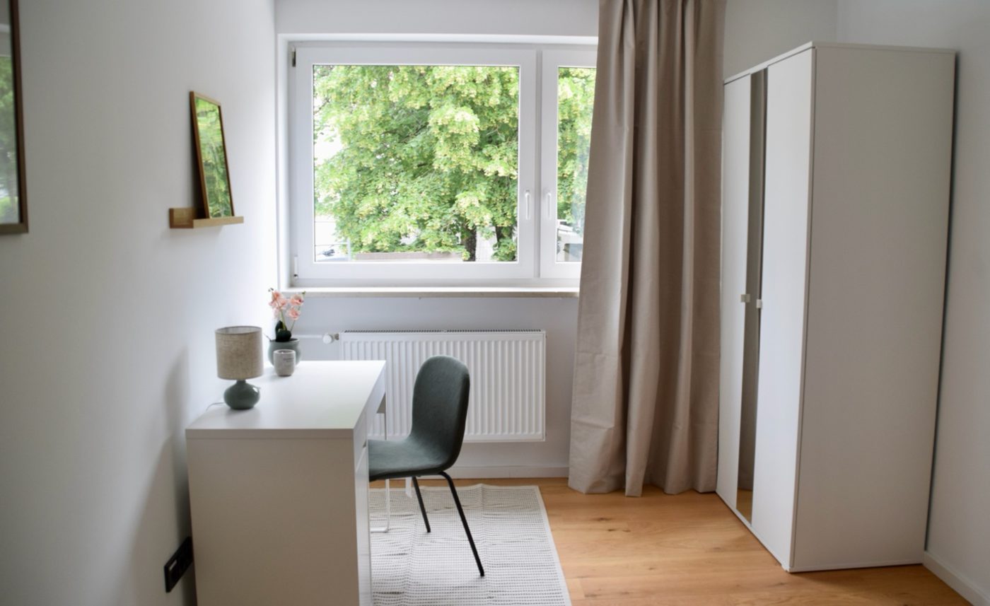 Fertiger heller Wohnraum mit Echtholzboden, Schreibtisch und Fenster